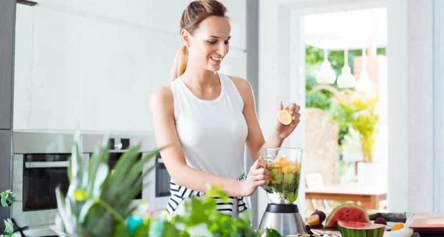 Mulher usando o Liquidificador na cozinha